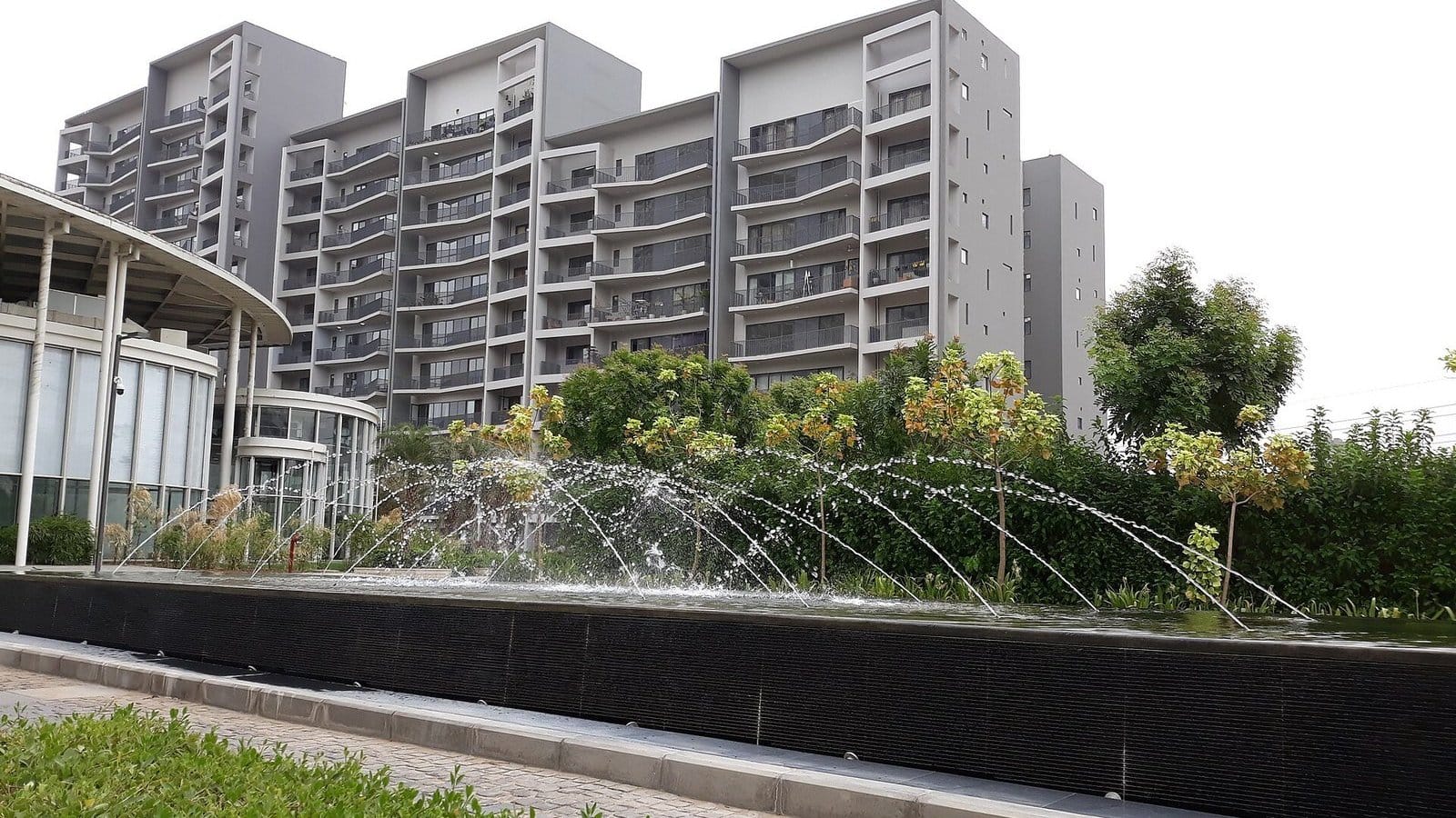 Grey Ireo Skyon apartment towers behind a fountain and garden in neighbouring Sector 60, on Golf Course Extension Road