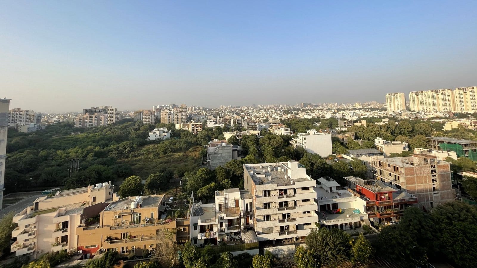 Rooftop view looking north over independent floors, trees and apartment towers in Sector 47, Gurgaon, the sector that holds Malibu Towne