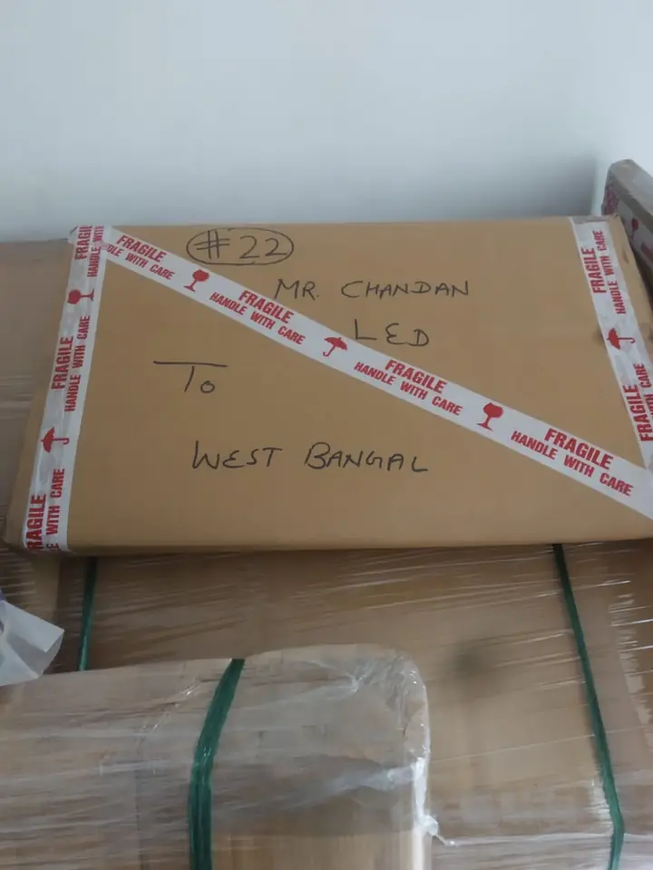 Flat LED TV carton numbered 22, criss-crossed with FRAGILE HANDLE WITH CARE tape and labelled “LED, to West Bengal”