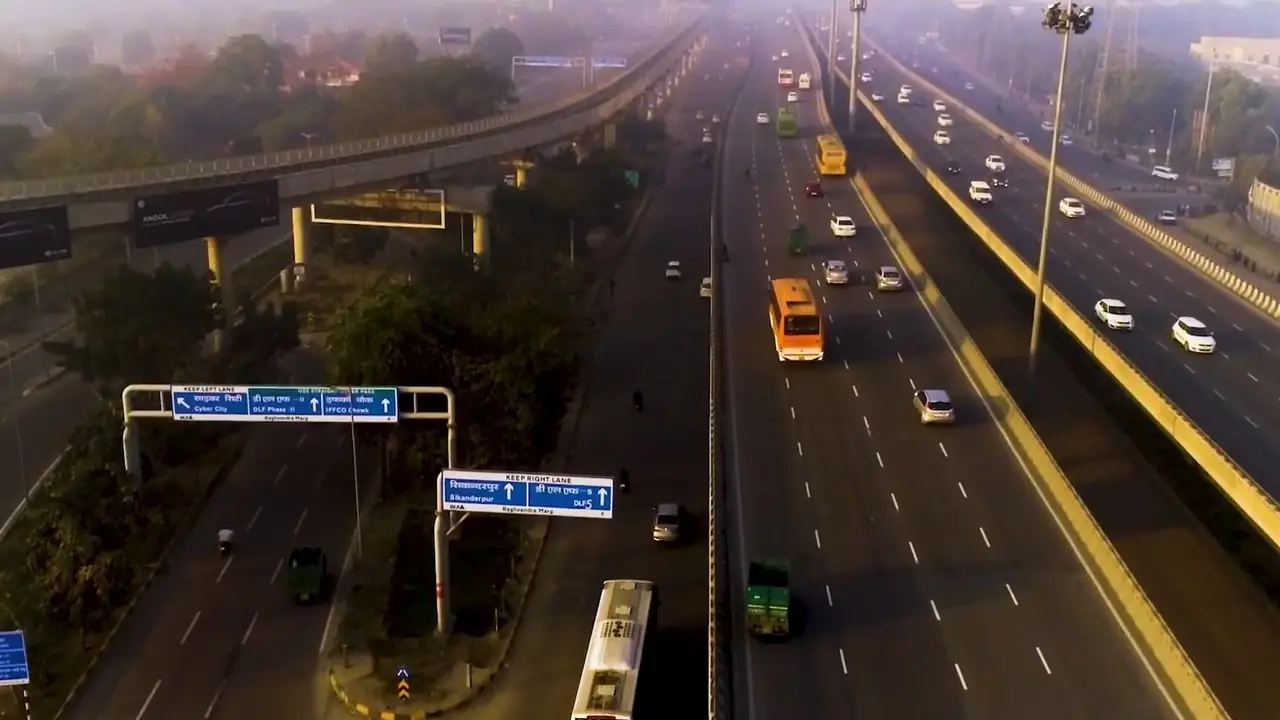 Illustration: aerial view of the multi-lane highway at the Cyber City and Sikanderpur turn-off, with the Rapid Metro viaduct and signs for Cyber City, DLF Phase 2, IFFCO Chowk, Sikanderpur and DLF Phase 5.