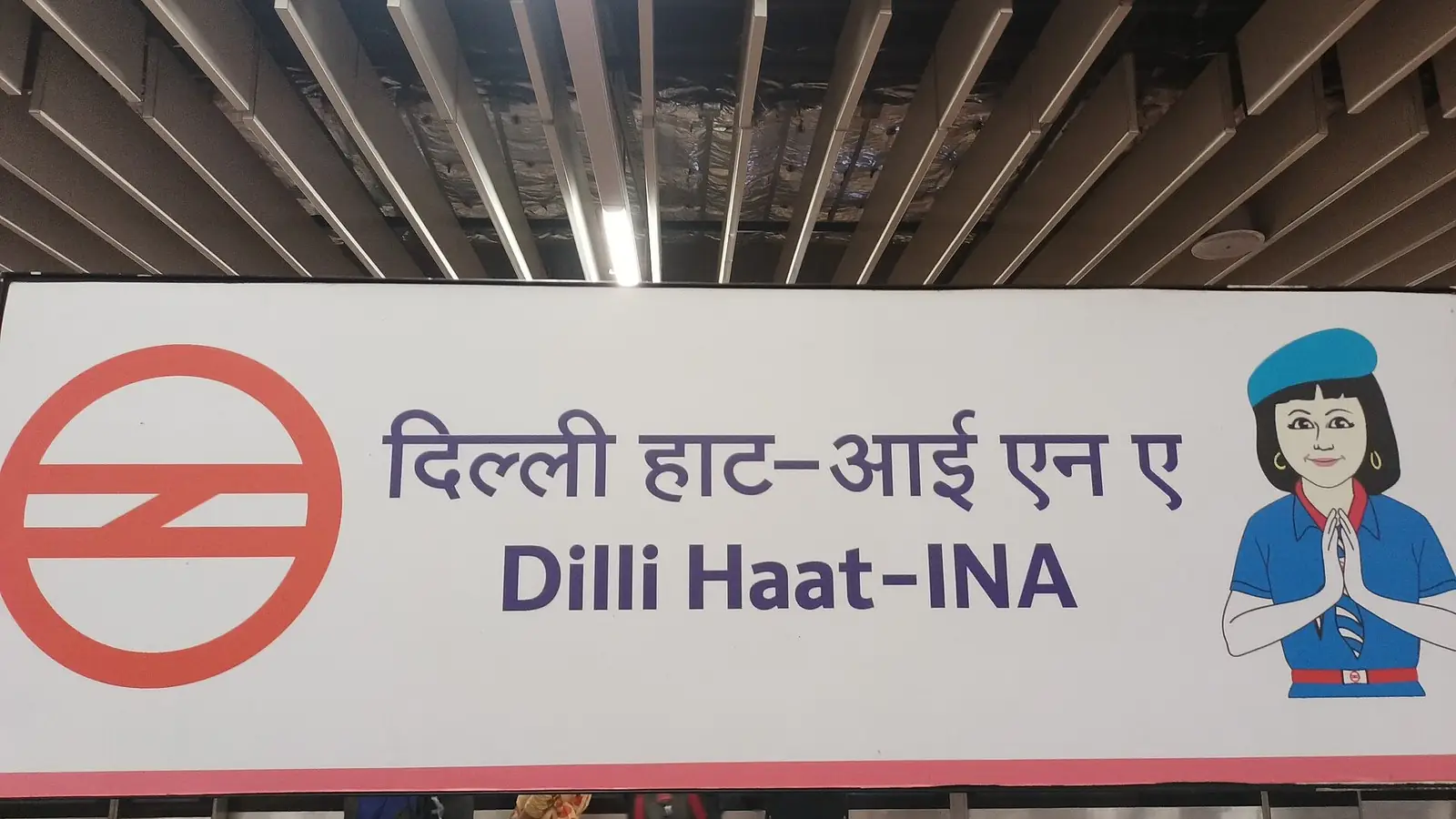 Illustration: name board of Dilli Haat-INA metro station, the interchange serving INA.